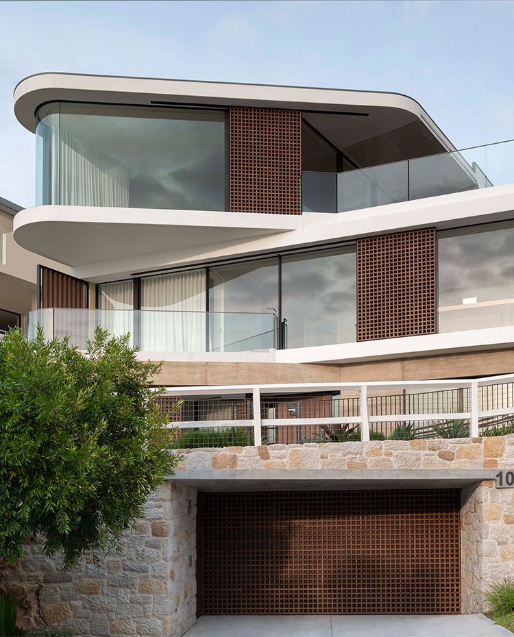 Fachada exterior con entrada al garaje y cerramientos de cristal