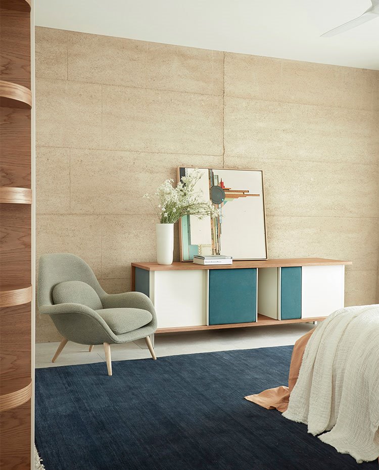 Mueble contenedor y butaca a los pies de cama, alfombra en azúl
