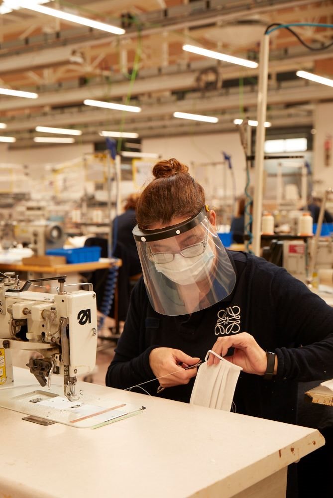 Una trabajadora de Loewe realizando mascarillas que contribuyan a minimizar el riesgo de contagios.