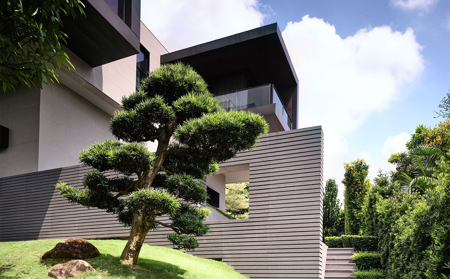 Lateral con escaleras exteriores con vegetación y zona ajardinada