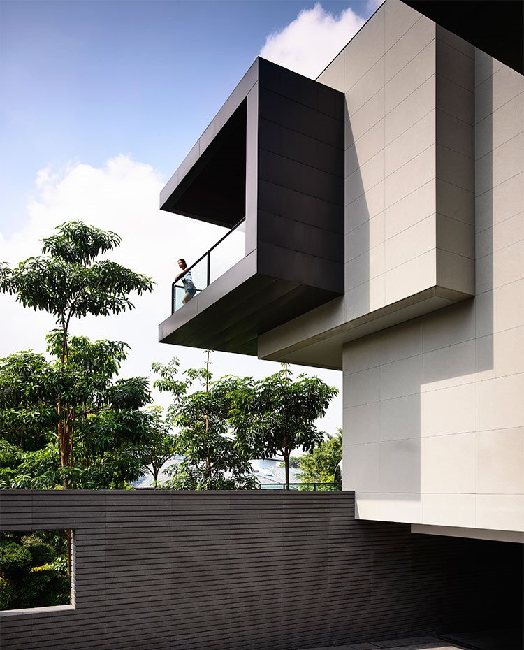 Vista de fachada lateral con superposición de prismas y terraza con balcón en cristal