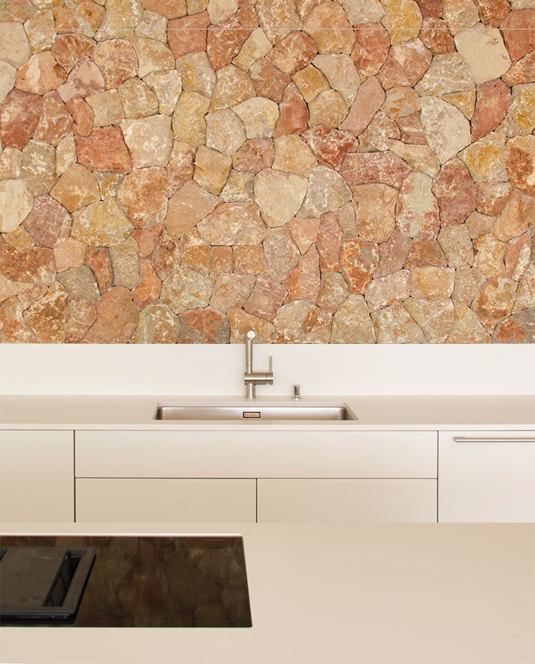 Frente de piedra en cocina, con mobiliario en blanco