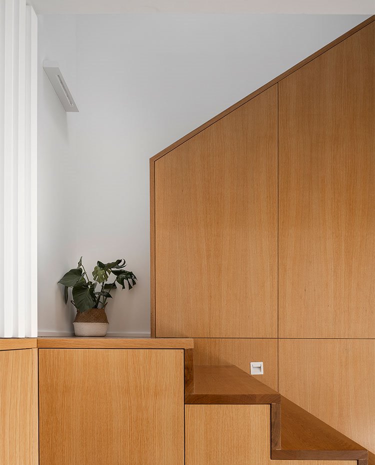 Detalle escaleras revestidas de madera, pared en blanco