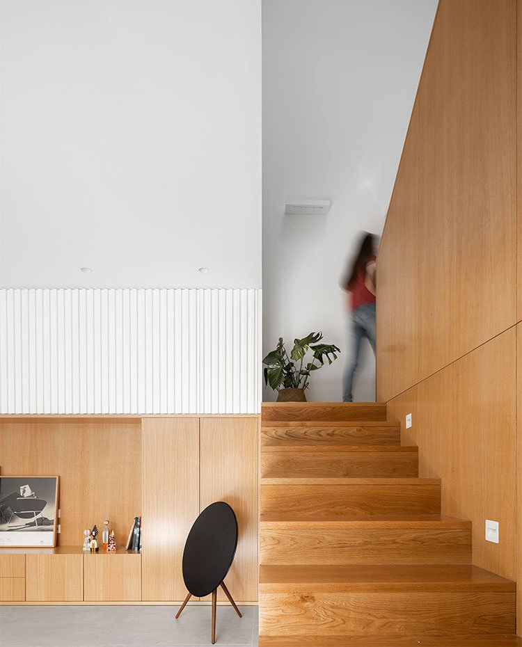 Escaleras revestidas de madera con iluminación integrada en panelado