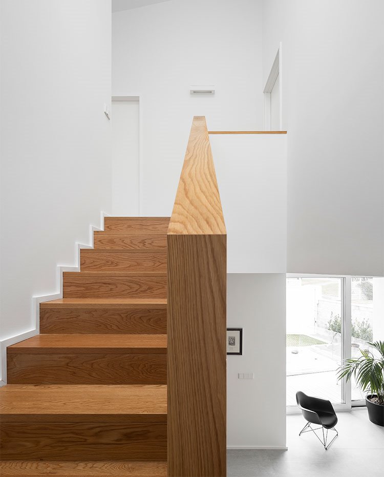 Escaleras revestidas de madera con pasamanos a juego.