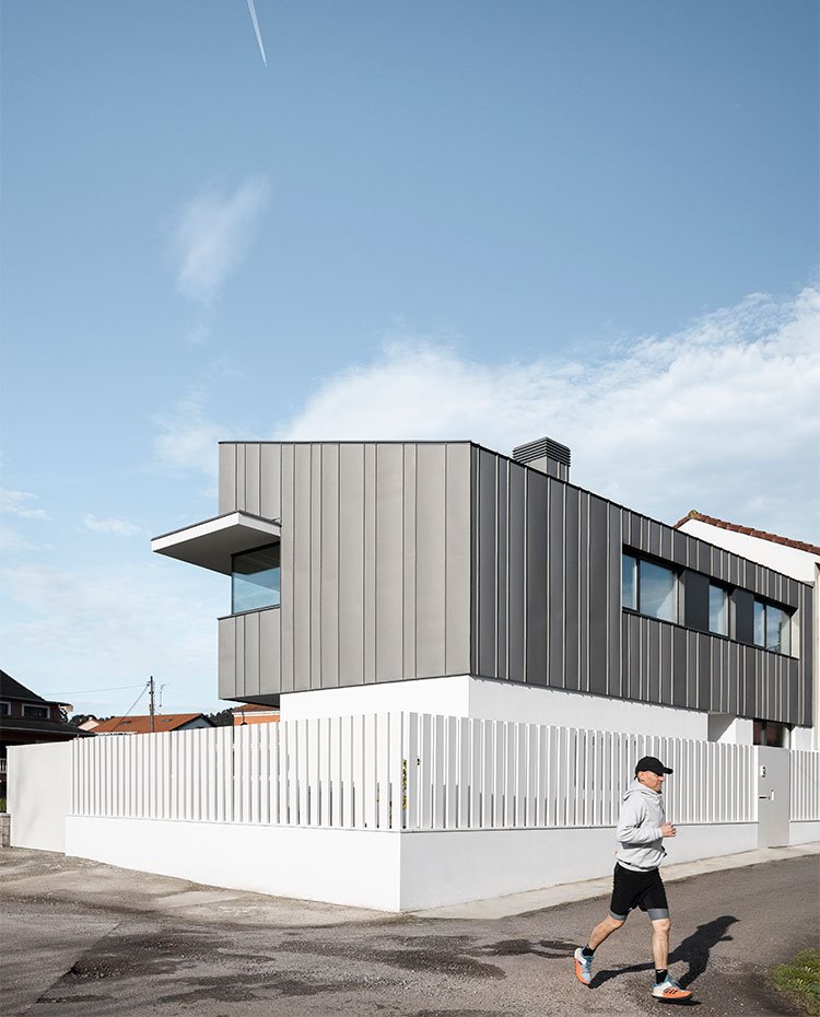 Vista exterior de vivienda con estructura blanca delimitando parcela