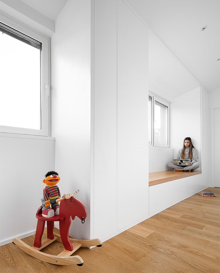 Zona de paso con armarios de almacenaje y zona habilitada con asiento de madera