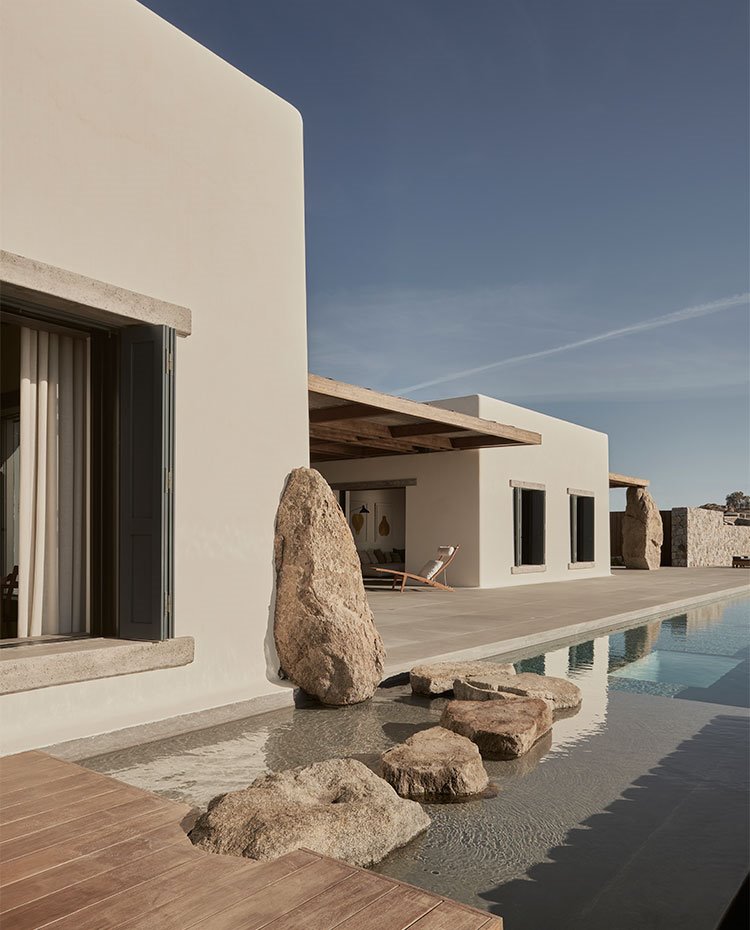 Detalle lateral de piscina con tarima de madera y piedra