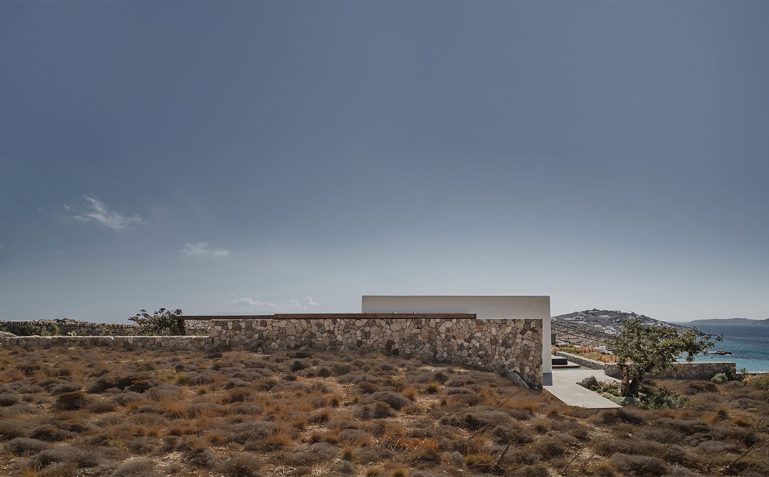 Vista exterior de vivienda con perímetro amurallado en piedra autóctona