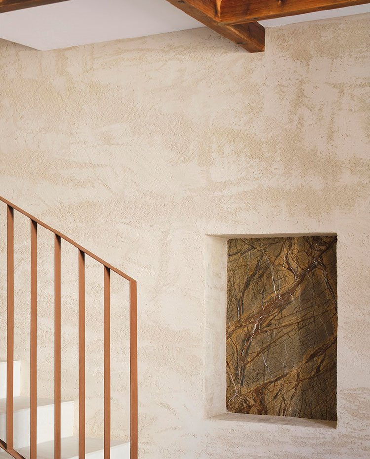 Detalle de escalera con hornacina en pared pared de tonos ocre con estuco tipo veneciano