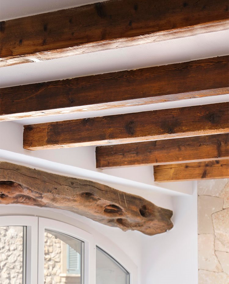 Detalle de vigas de madera en el techo y sobre ventanas