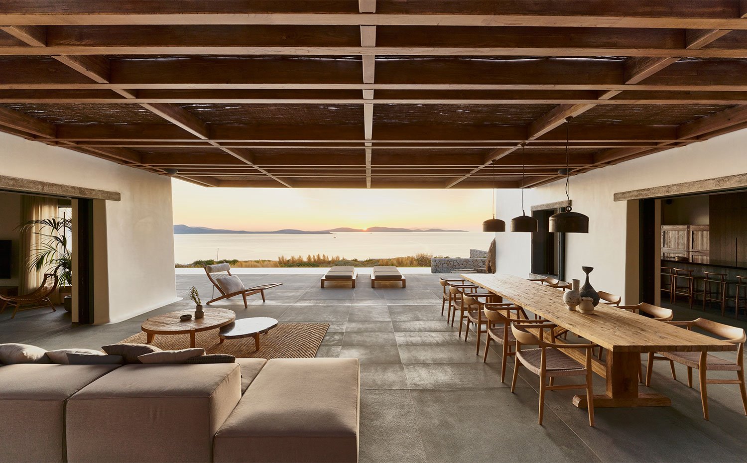 Porche exterior con sofá y mesa de comedor con vistas al mar