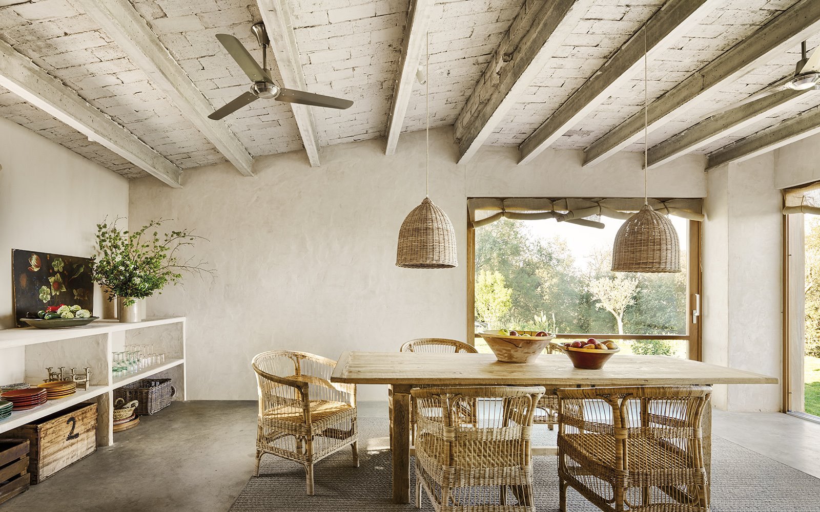 Comedor de la casa de Sandra Tarruella con paredes encaladas y vigas de madera