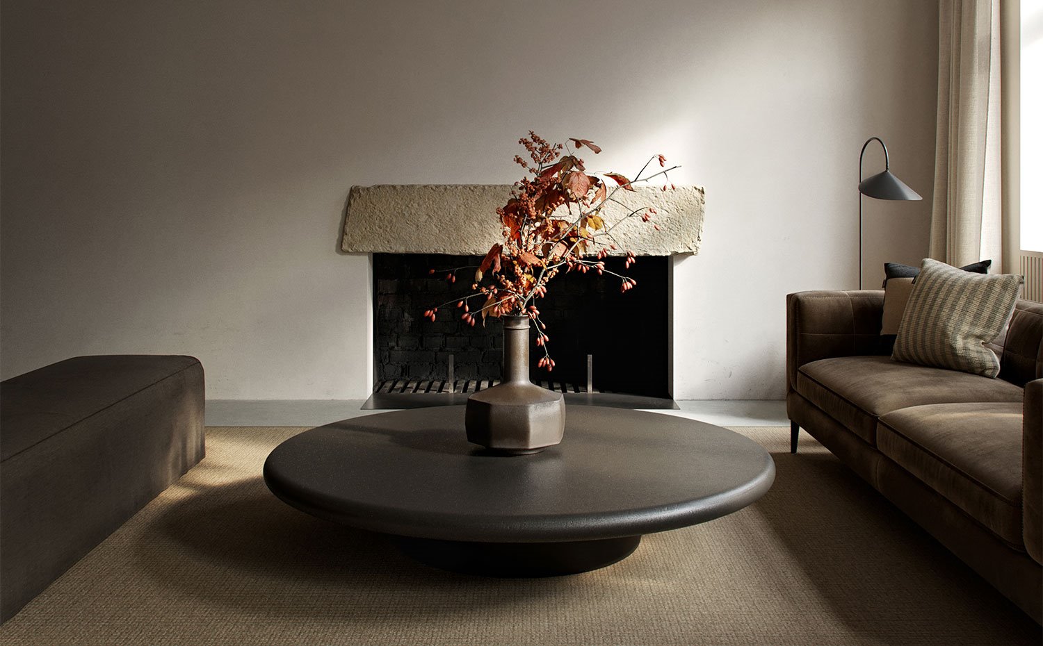 Salón con sofás y mesa central circular con chimenea al fondo
