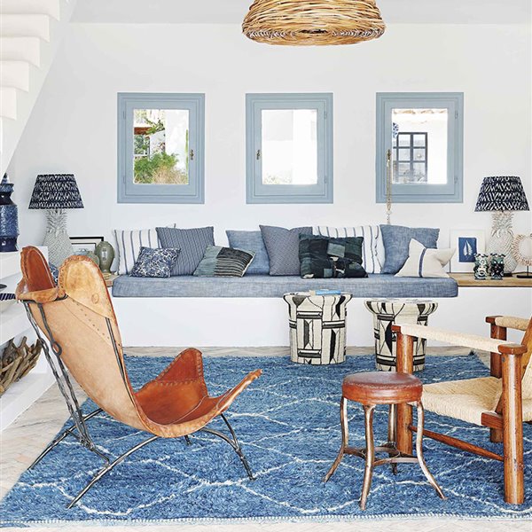 Salon con paredes blancas y cojines en colores azules