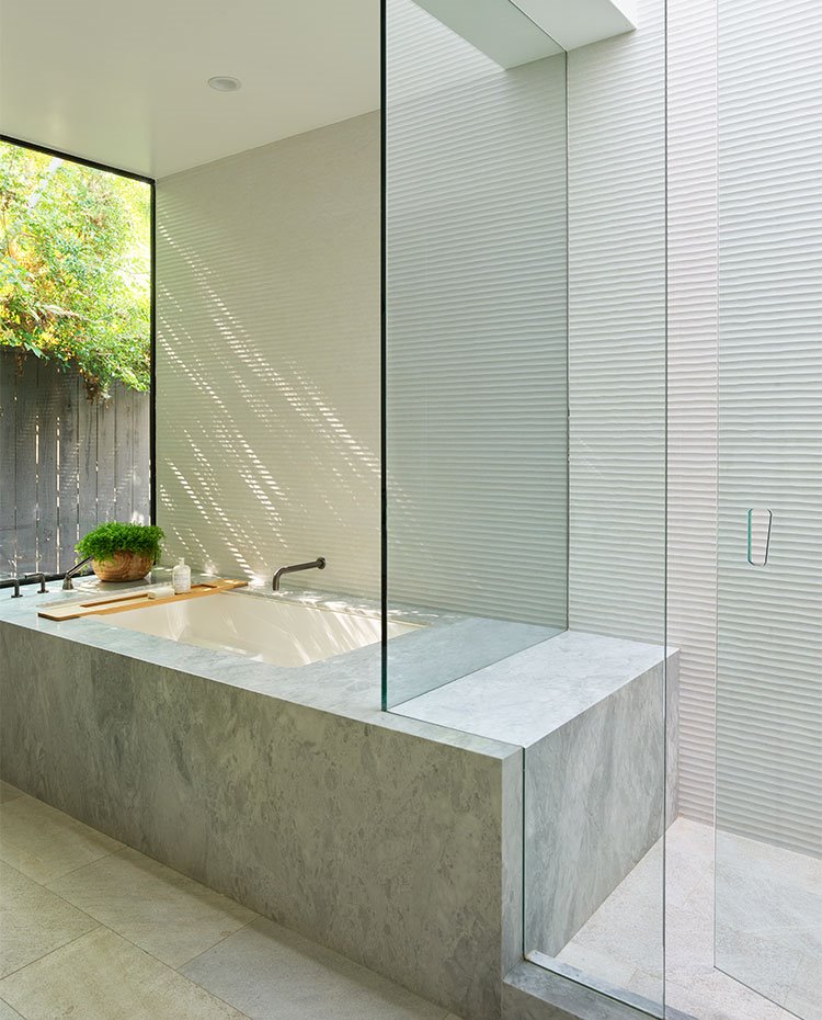 Cuarto de baño con ducha y bañera de obra de piedra con cerramientos acristalados