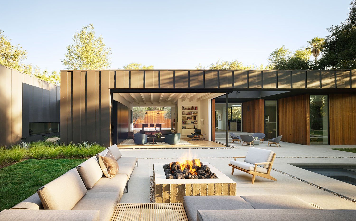 Terraza exterior con chimenea de obra, zona ajardinadaentorno a piscina y mobiliario exterior 