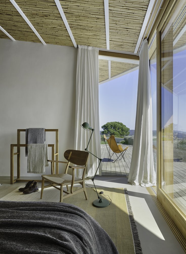 Dormitorio con ventana cortinas y galan de noche para ventilar la ropa