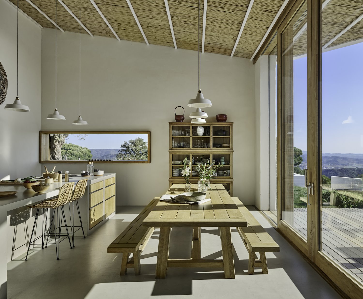 Cocina con comedor y bancos techo con vigas proeycto de 05 AM Arquitectura Foto Eugeni Pons
