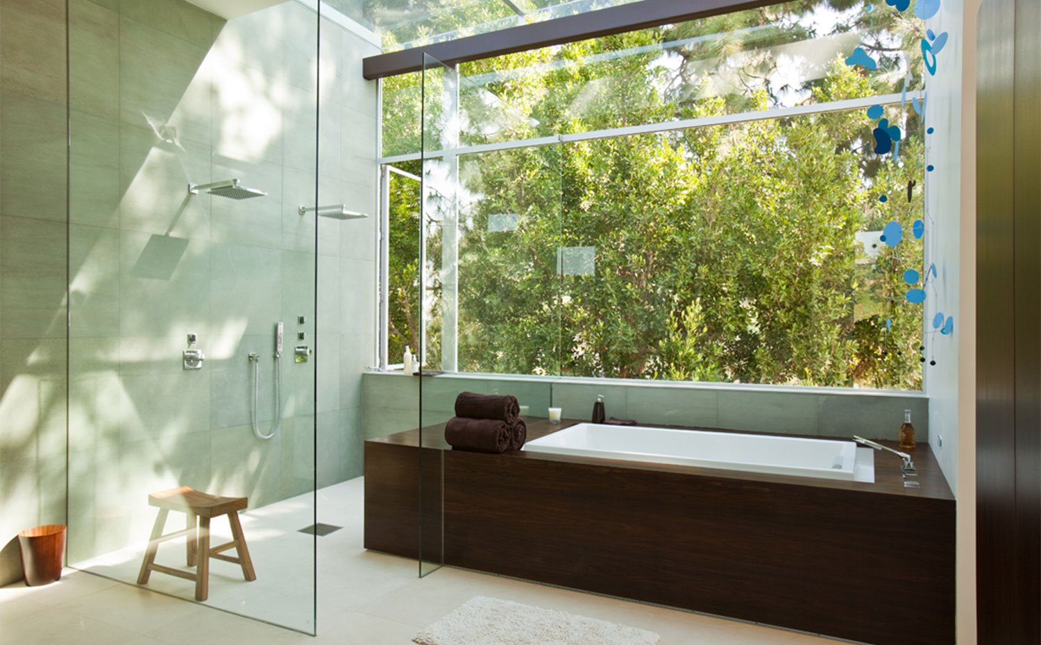 Cuarto de baño con ducha y bañera con grandes aperturas hacia exterior 