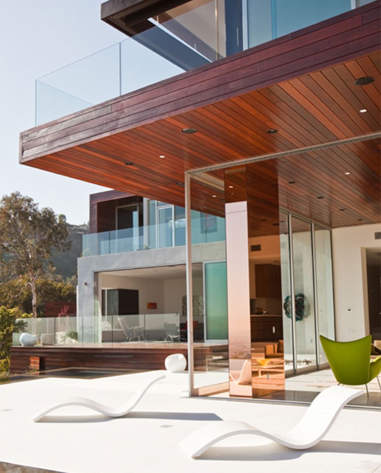 Exterior de vivienda con estructura de fachada en listones de madera y cristal 