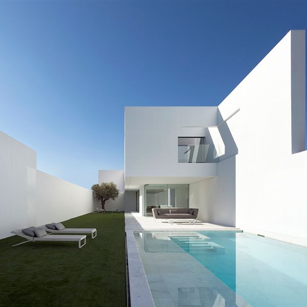 Exterior vivienda con tumbonas sobre cesped junto a piscina