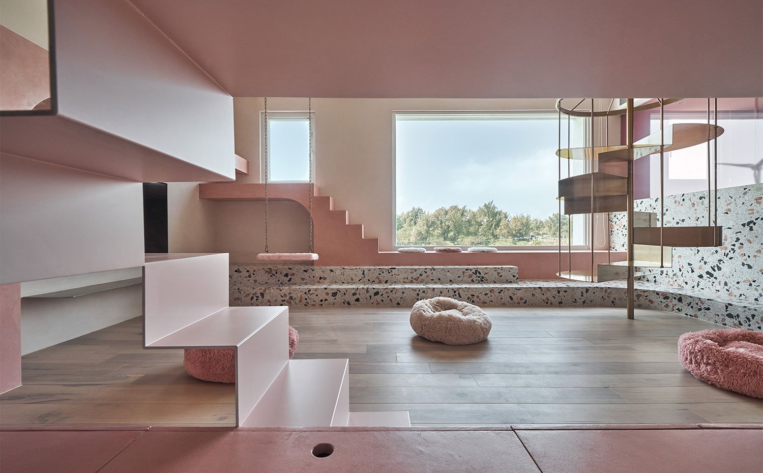 Lateral de zona de estar con columpio, poufs en rosa y escalera circular