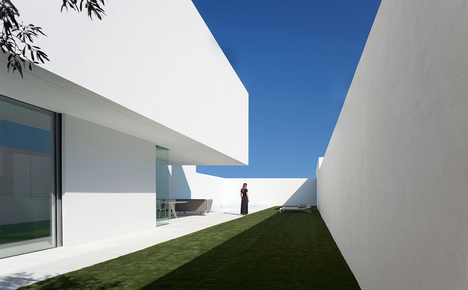 Lateral vivienda con apertura de suelo a techo y césped exterior