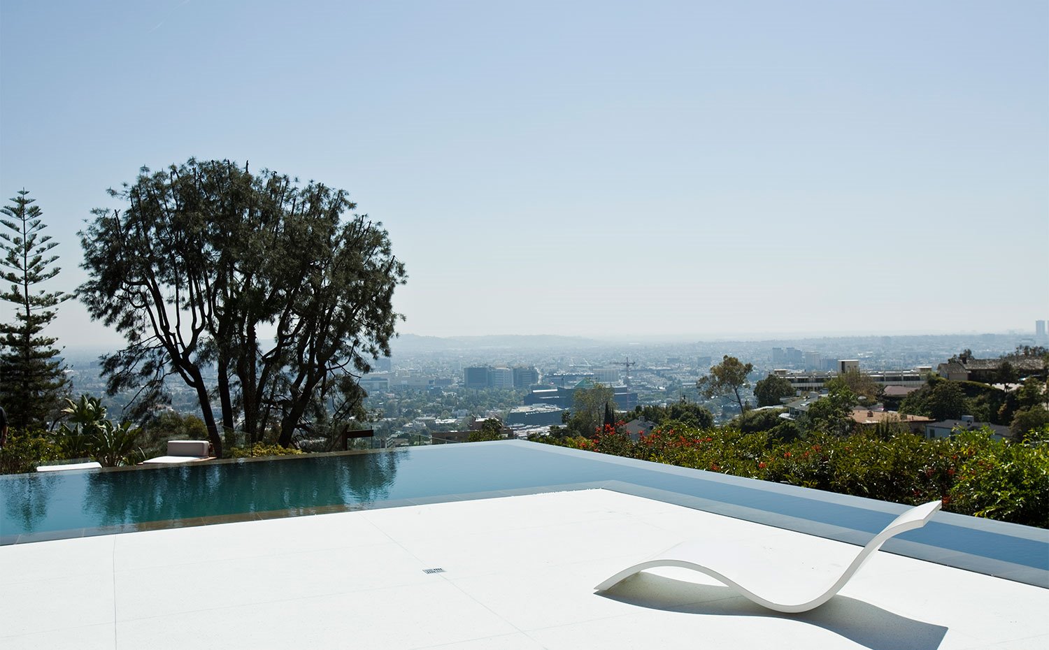 Piscina desbordante y tumbona de formas ondulantes frente a la ciudad de Hollywood