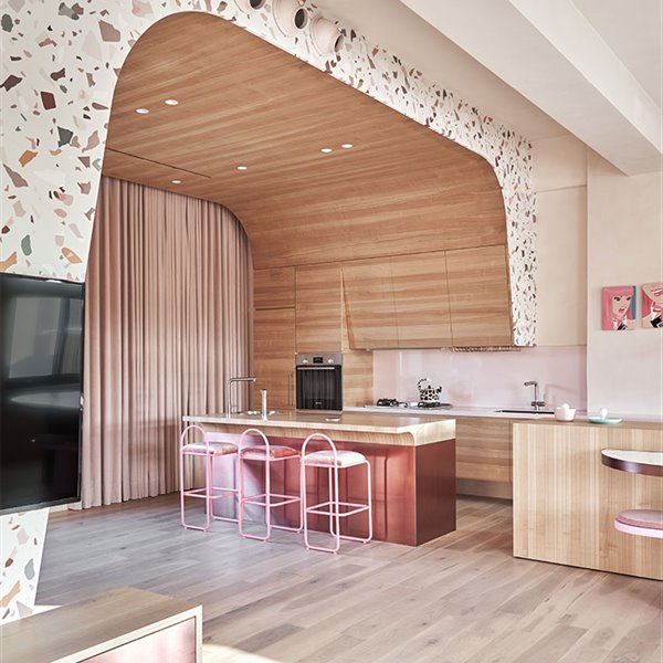 Zona de cocina con isla central bajo estructura revestida de madera y mármol