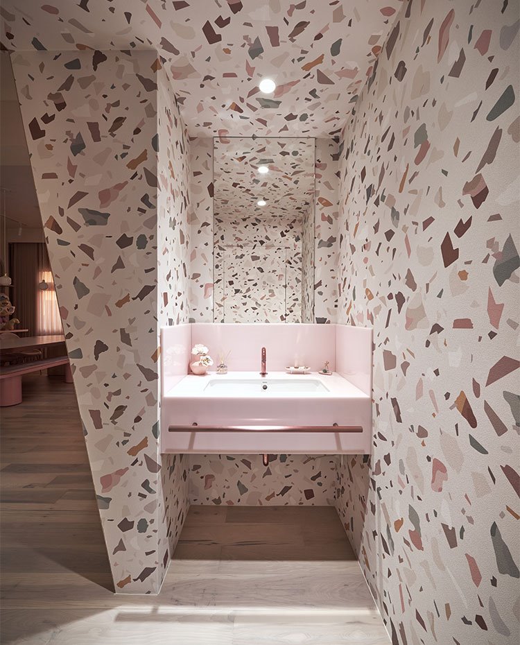 Zona de tocador de cuarto de baño con estructura en rosa y revestimiento tipo mármol