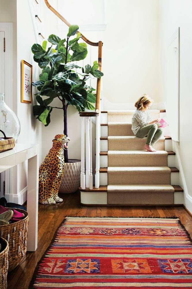Escalera con alfombra étnica y figura de porcelana de un leopardo