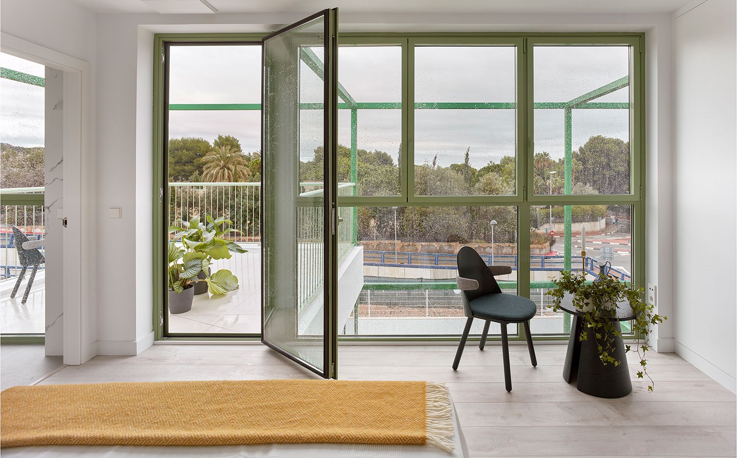 Dormitorio con cerramientos acristalados y perfilería en verde