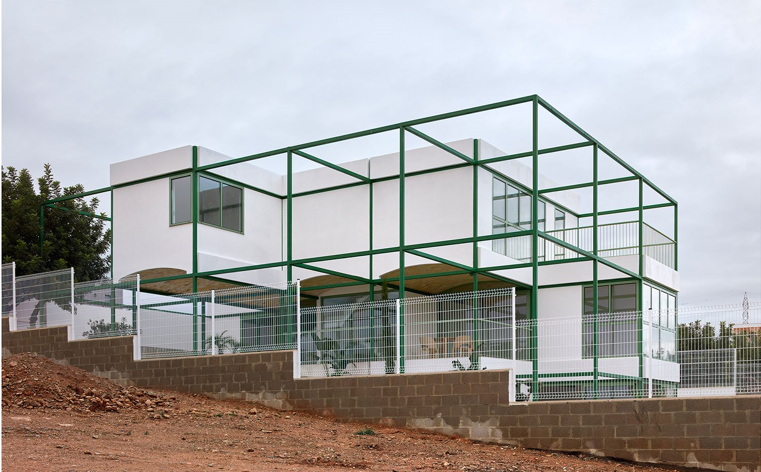 Exterior de vivienda con fachada en blanco y estructura en verde