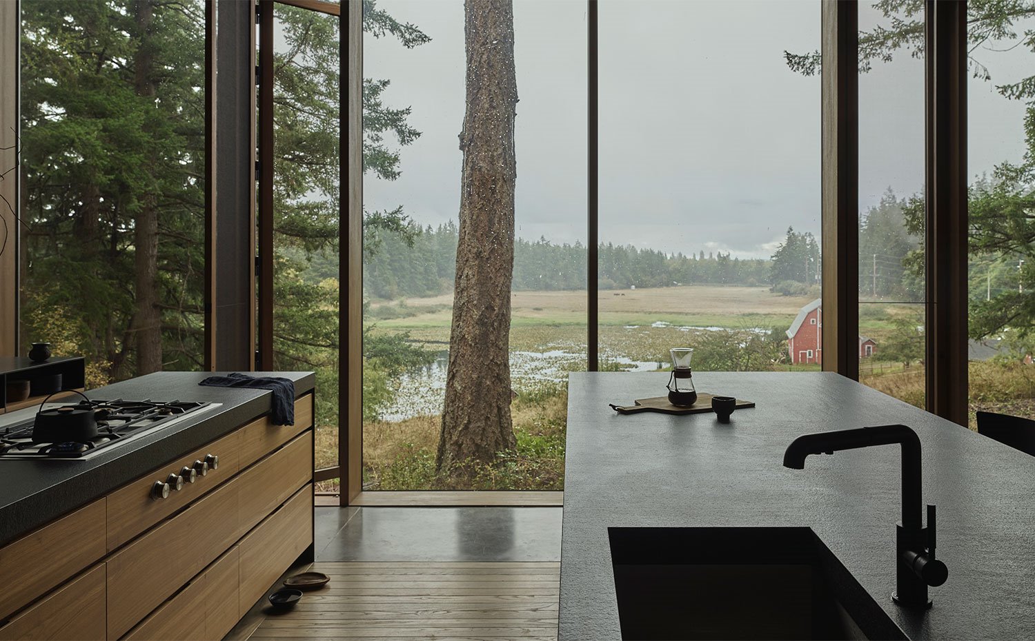 Doble isla de trabajo en la cocina abierta con amplios cerramientos de cristal con vistas al exterior