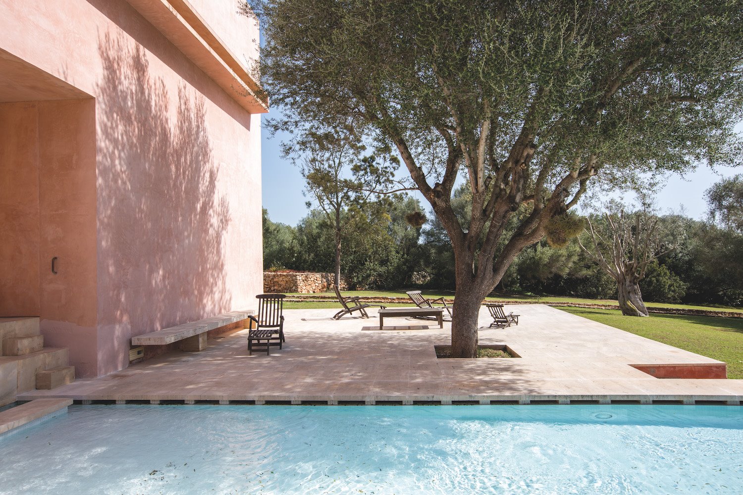 Casa de color rosa de claudio Silvestrin y John pawson en Mallorca arboles junto a la piscina