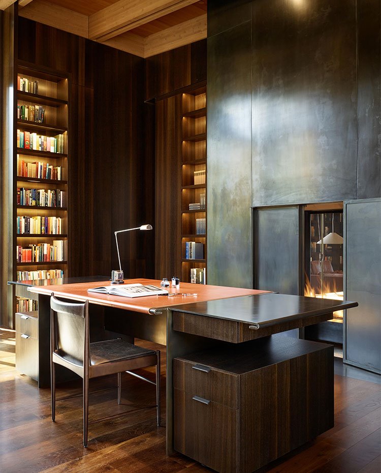 Sala de trabajo con amplias librerías y chimenea, mobiliario todo de madera