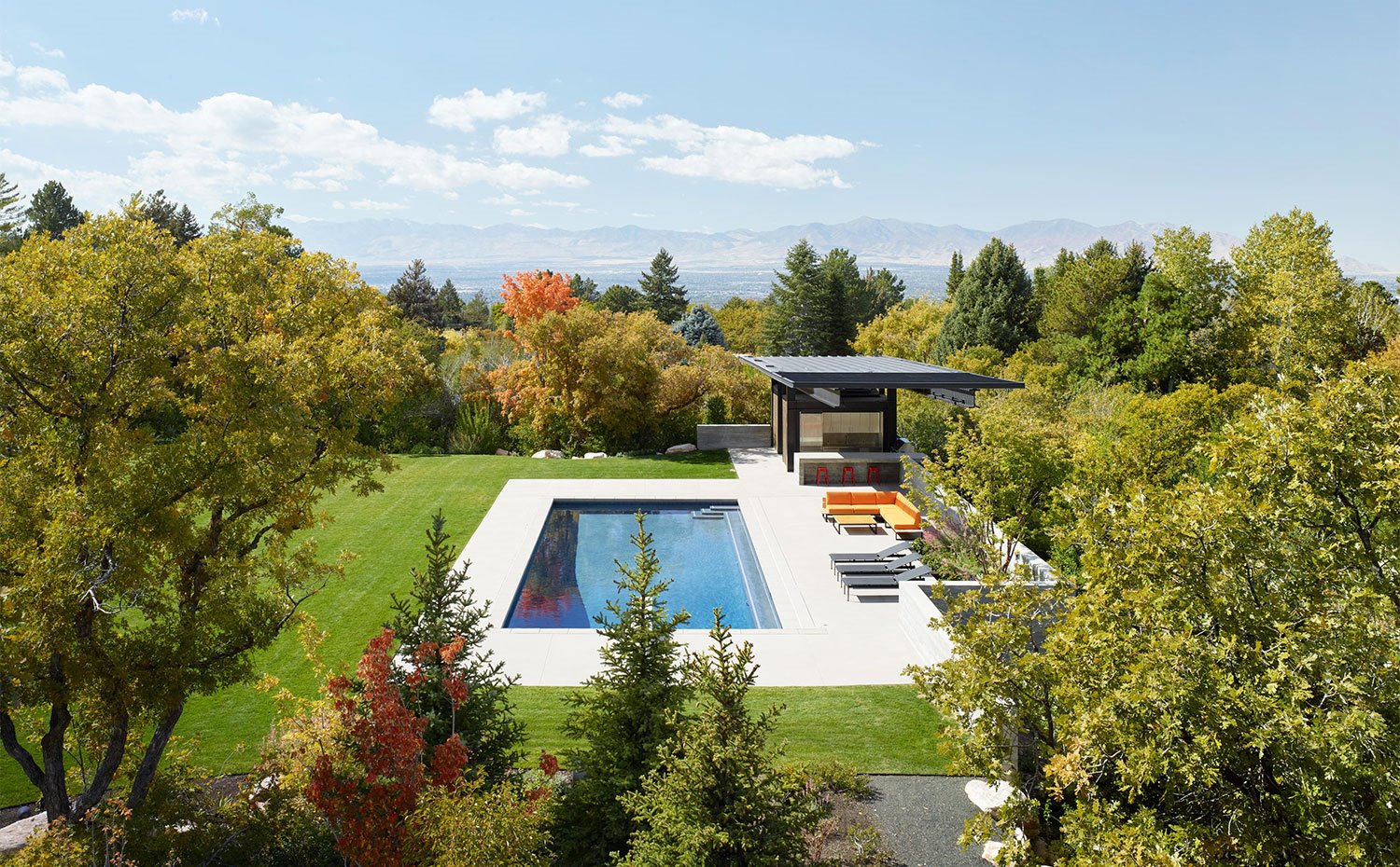 Vista de la piscina y el jardín, rodeados de naturaleza
