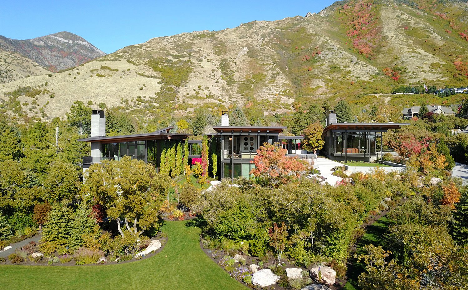 Vista genera de vivienda con montaña al fondo y rodeada de árboles