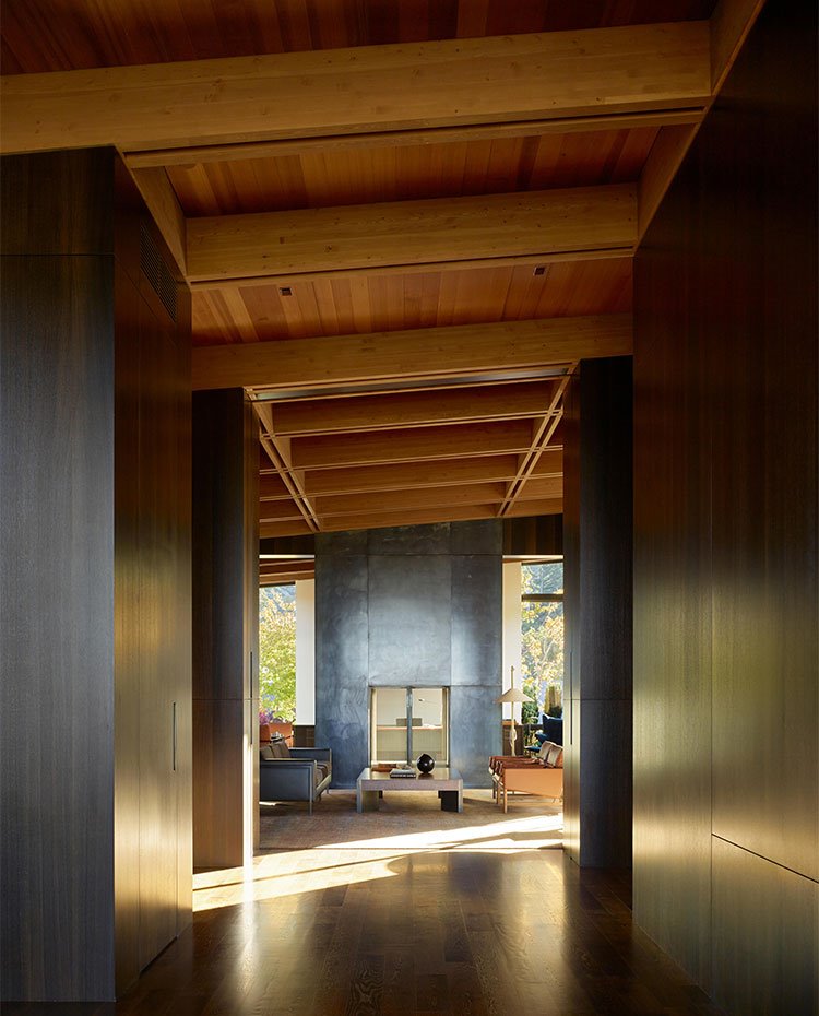 Zona de paso hacia salón con techo de madera y revestiminetos de pared de madera