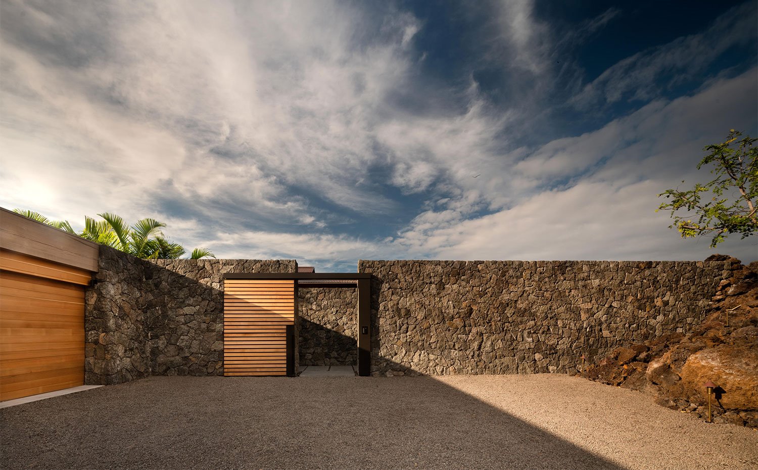 Acceso puerta de la vivienda con muro de piedra y puerta de madera