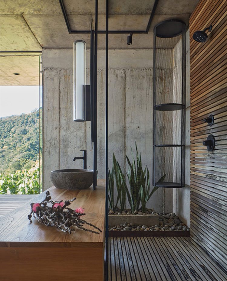 Mueble tocador en madera y ducha el láminas de madera, grifería en negro y vistas al exterior