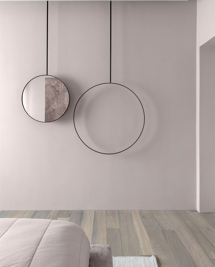 Detalle escultural circular en pared en tonos rosados en dormitorio
