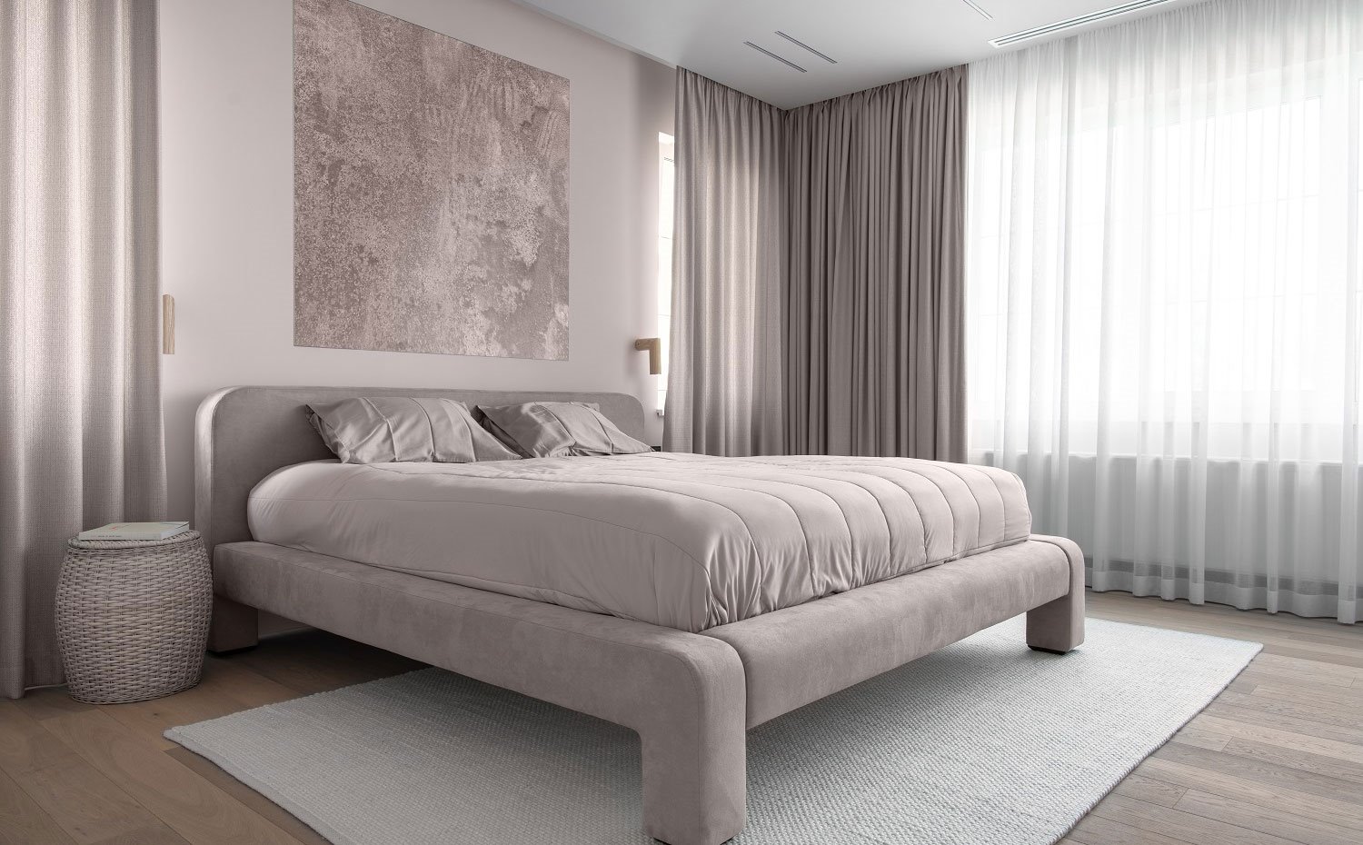 Dormitorio con lenceraría de cama y detalles en tonos grises rosados, mesilla a modo de cesto y alfombra en crudo sobre suelo de madera