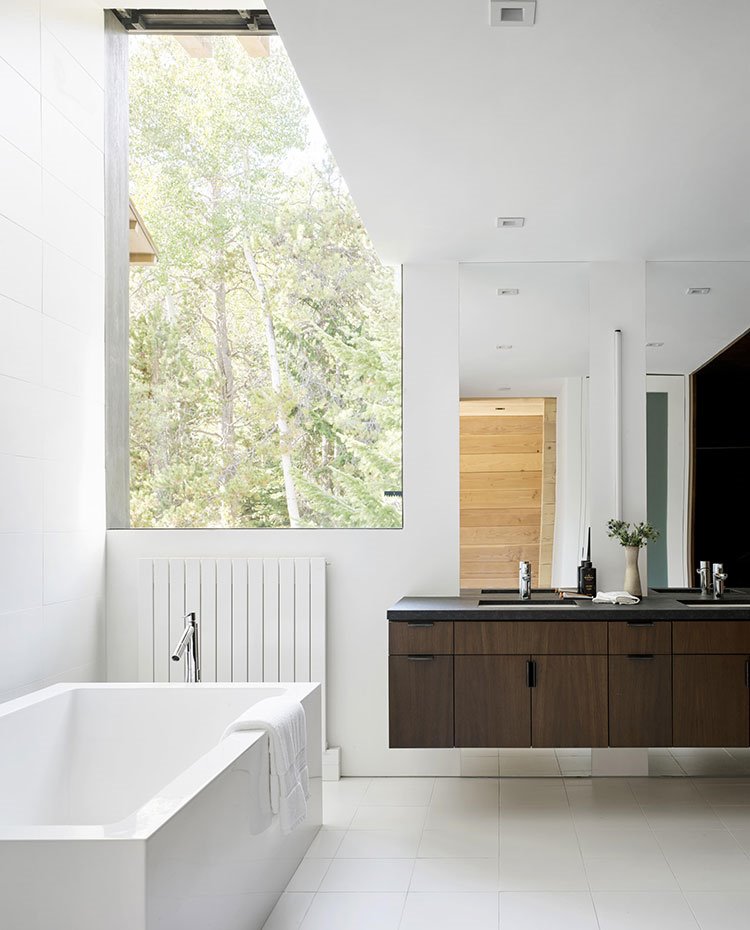 Cuarto de baño en blanco con mobiliario de bajolavabo suspendido en madera oscura