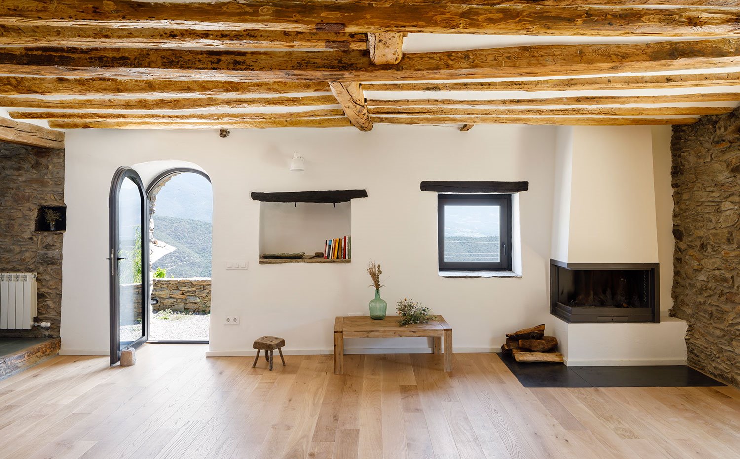 Frontal de la sala de estar con apertura abovedada hacia exterior, techos con vigas de madera