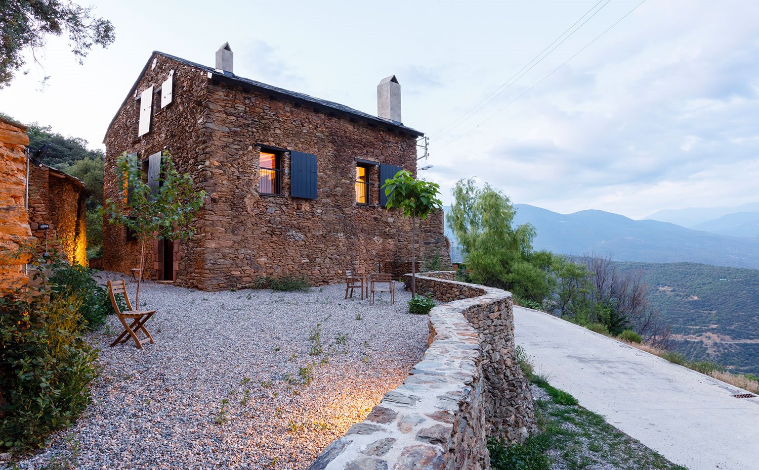 Murete de piedra bordeando el camino de acceso hasta la casa rural