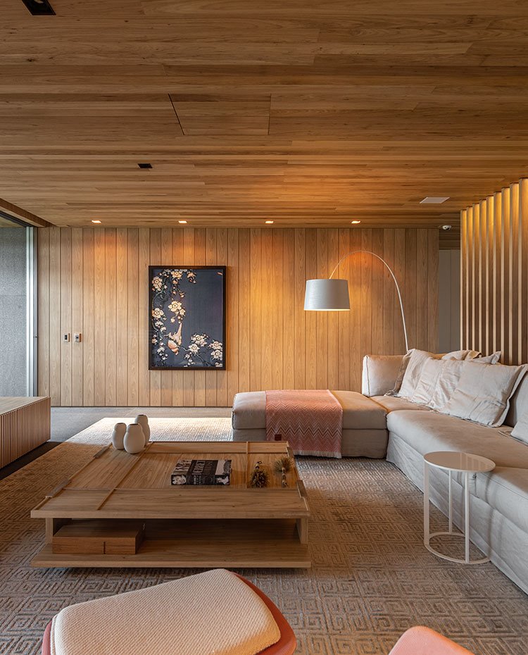 Salón con sofá en crudo, mesa en madera, mesita en blanco, alfombra con motivos geométricos