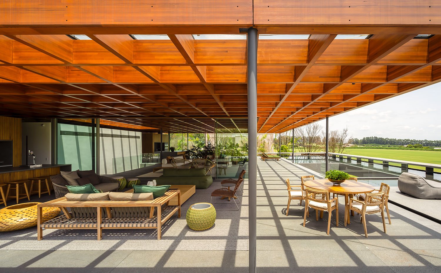 Salón y comedor exterior junto a interior de vivienda con cerramientos acristalados y piscina