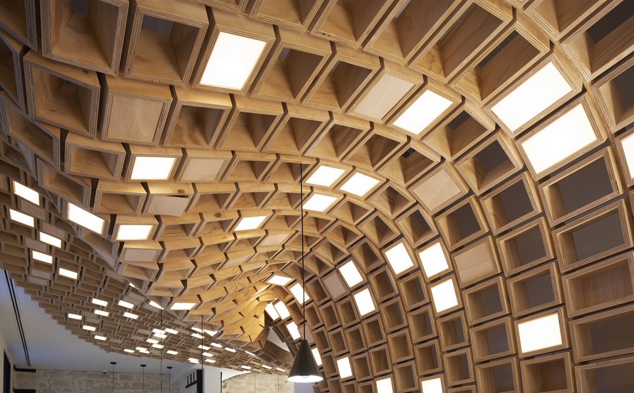 La estantería, formada por 800 cajas de 8 tamaños distintos, se alza desde el suelo hasta cubrir el techo con una estructura ondulada.
